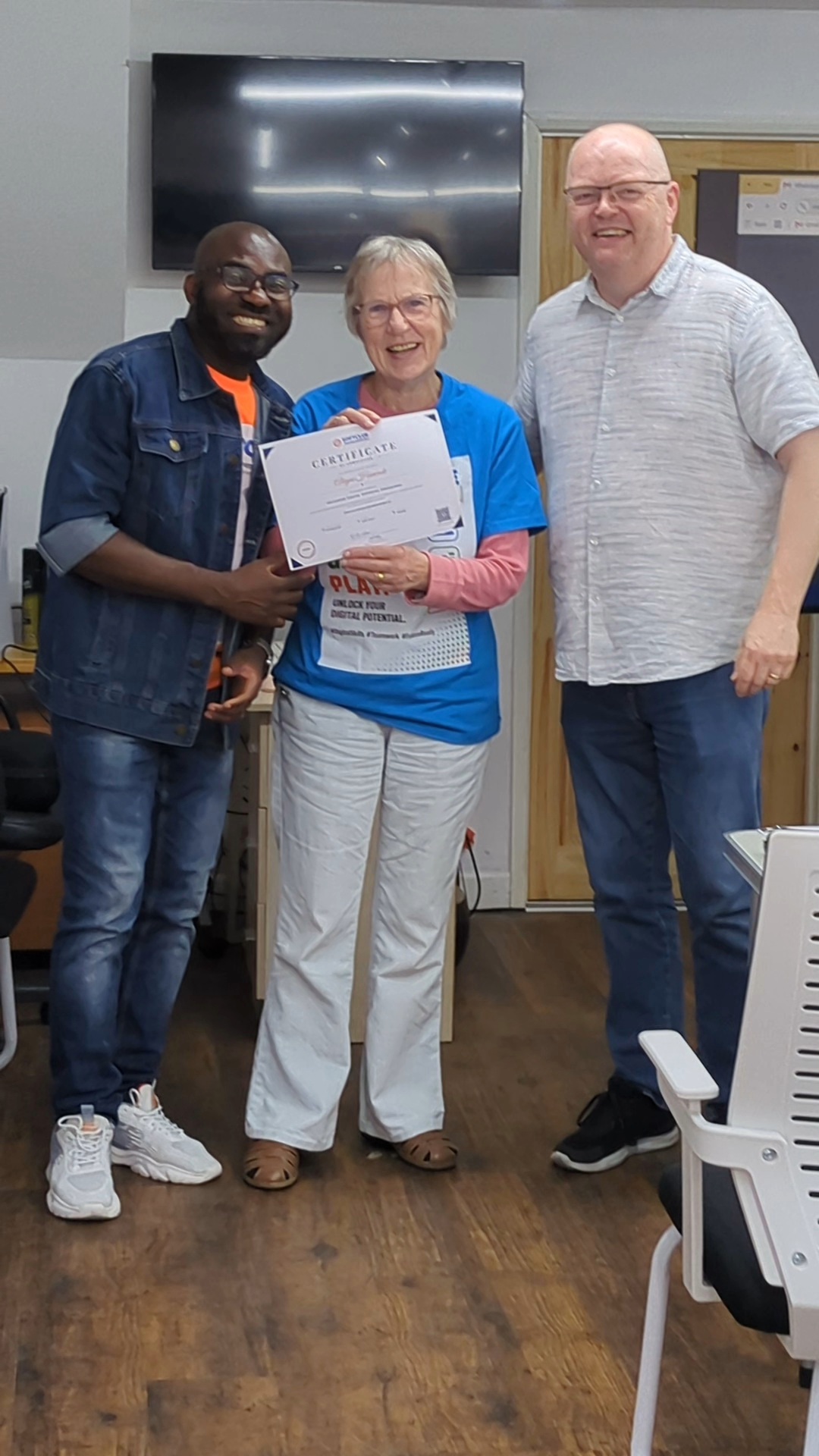Graduate celebrating her certificate with the programme team