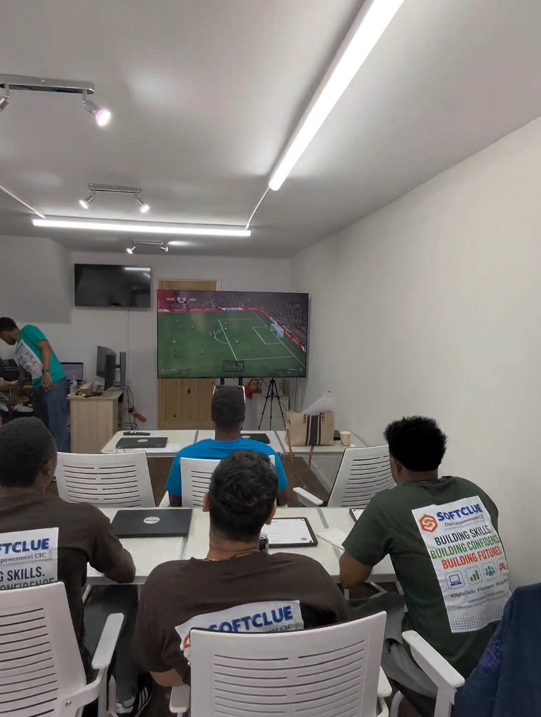 Learners watching a football match together during a break